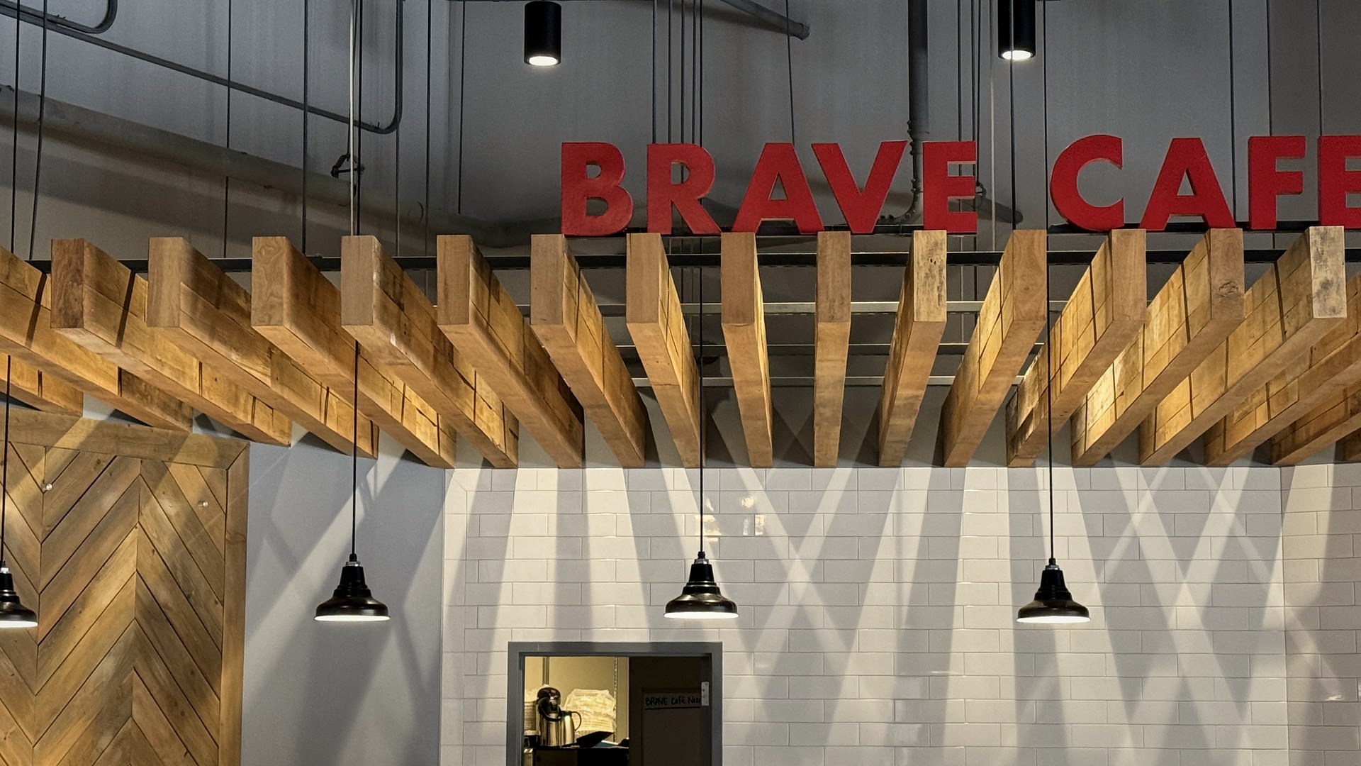 Pendant and track lighting over the Brave Cafe coffee bar after the Colpitts Electric LED retrofit