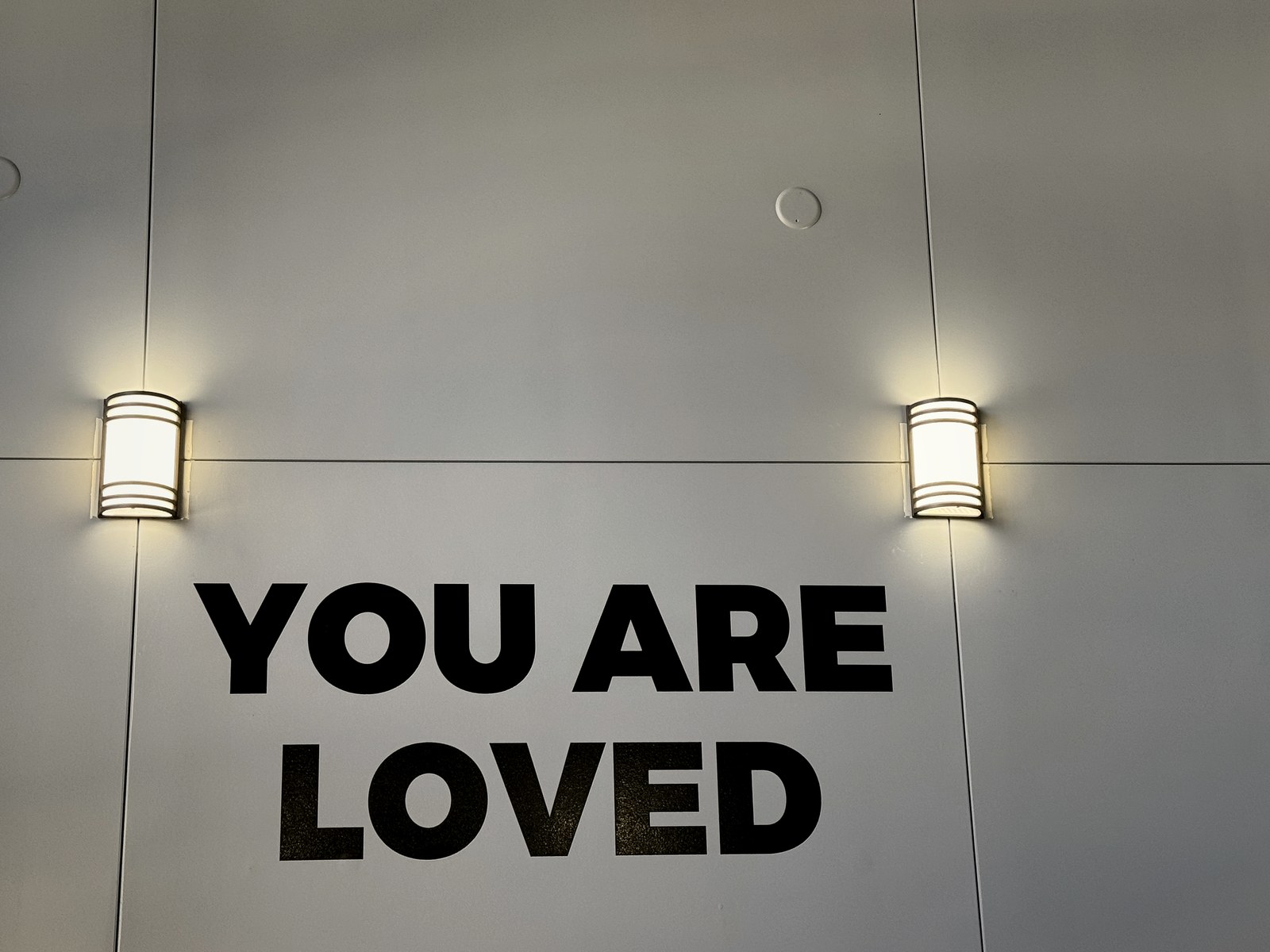 LED wall sconces washing the YOU ARE LOVED accent wall at BRAVE Church